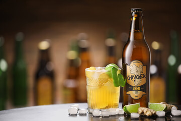 Bottle and glass of fresh ginger beer on table in pub