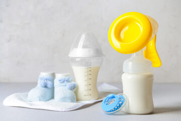 Breast pump and baby accessories on light background