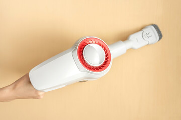 Female hand holding a portable vacuum cleaner.