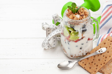 Healthy breakfast with jar of granola, yogurt and fresh berries