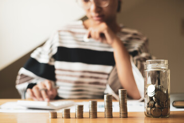 Women are calculating financial graphs with coins to save money, grow a successful business and save for retirement. Retirement Savings concept