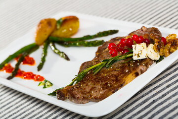 Fried veal cutlet with roasted vegetables decorated with fresh rosemary