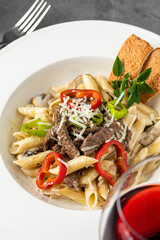 With sliced ​​grilled meat on a creamy penne pasta.