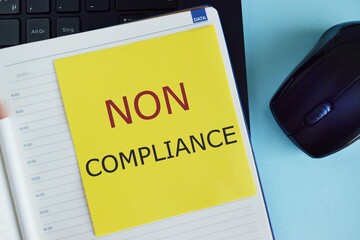 Non Compliance text written on colorful sticker in Notebook. Business concept