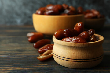 Bowl with dried dates on wooden table