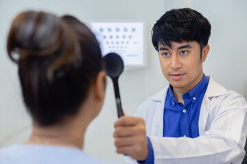 Optometrist examining eyesight for woman before made glasses in clinic. Ehecking eye vistion by optician health examination concept.