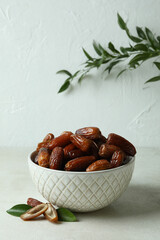 Bowl with dried dates on white textured table