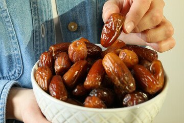 Woman in jeans shirt hold bowl of dates