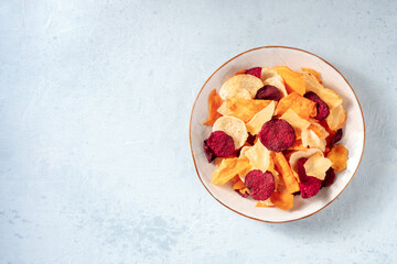 Fruit and vegetable chips on a plate, overhead shot