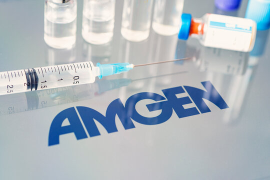 Vials of liquid on a white table and the logo of a large pharmaceutical company.