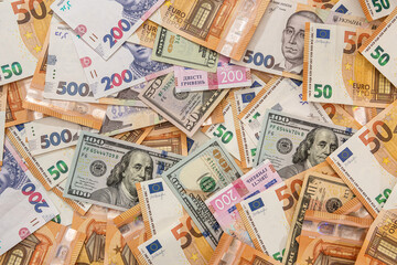 Money background from different countries dollars euro and hryvnia banknotes