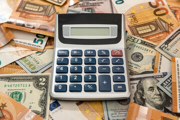 Business financial accounting dollar and euro banknotes with calculator on desk