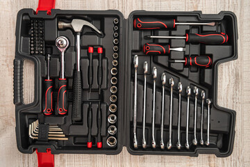 new set of wrenches and bits in tool box on wooden desk