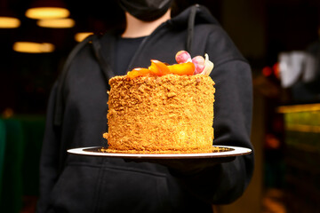 Whole Cake Napoleon served by waiter in restaurant or cafe. Party celebration, birthday party present.