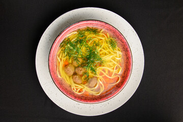 Chicken noodle soup, miso ramen soup in a bowl over black background. Asian cuisine concept.