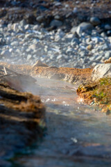 steam comes from a warm stream in cold mountains / thermal spring