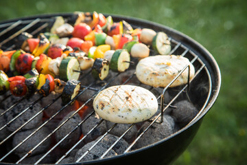 Vegetarisches grillen mit bunte Gemüsespieße und Grillkäse grillen mit Rauch auf Holzkohle...