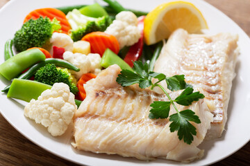 Plate of fried cod fish fillet with vegetables
