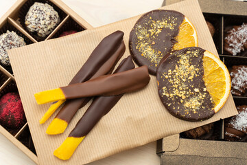 Craft chocolate handmade. Pieces of mango in chocolate, slices of dried orange chocolate on candy...