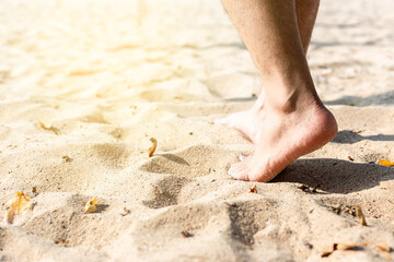Man leg walking on the sand on the beach with copy space
