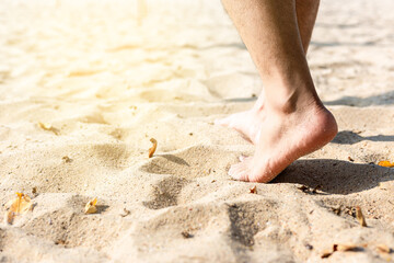 Fototapeta na wymiar Man leg walking on the sand on the beach with copy space