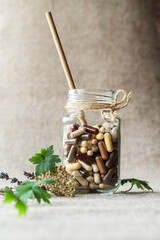 Cocktail of capsules with food supplements in glass jar