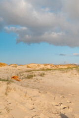 Red naranja de pesca tirada en las dunas de una playa con luz de atardecer