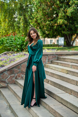 Naklejka premium sexy young woman in fashionable long green dress enjoy sunny summer day