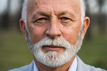 Close up portrait of senior man. Elderly man with wrinkled face is looking at camera.