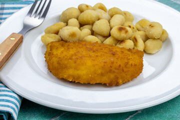 cordon bleu et gnocchis dans une assiette	