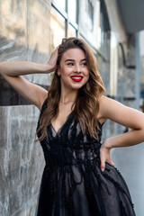 Fototapeta premium Young beautiful pretty girl posign in dress along in urban background