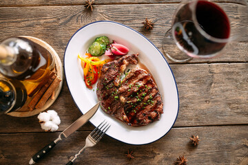 Top view on grilled beef steak with a glass of red wine