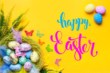 Congratulatory easter background. Easter eggs and flowers. Selective focus. Top view.