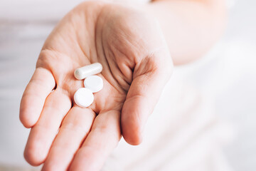 Medical pills tablets lie in woman's hand. Health and medicine. Selective focus