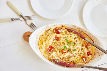 Trending viral recipe of baked tomatoes and feta with pasta, Fetapasta on a white wooden background. New, popular dinner dish, Top view, copy space..