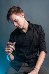 The guy keeps a glass of alcohol on a gray background