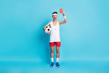 Full body photo of brunette angry man wear headband hold red card football scream isolated on blue...