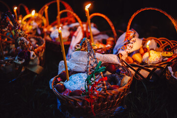 Easter food for blessing. People come to the Church to consecrate Easter cakes and eggs. Easter baskets and candles on a background of people near the church. Retro photo, film noise.