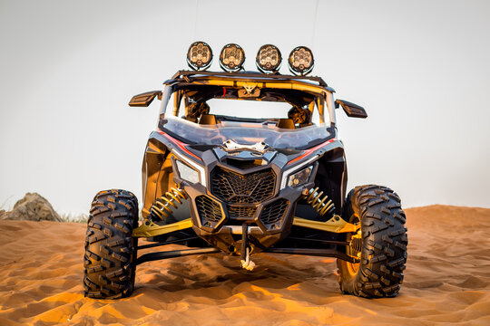 Modern dune buggy with light bar front view, parked on sand in the desert, Fossil Rock, Sharjah, United Arab Emirates.