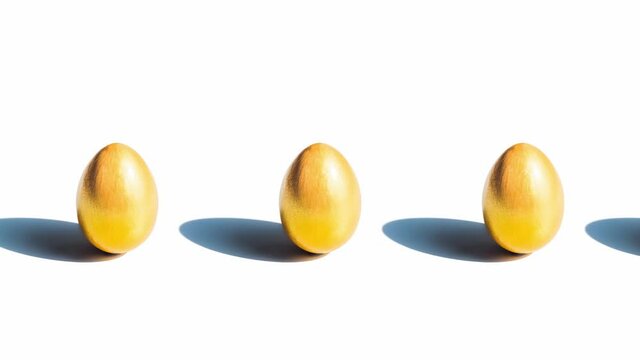 row of golden eggs on white background move from left to right, slider shot 4K