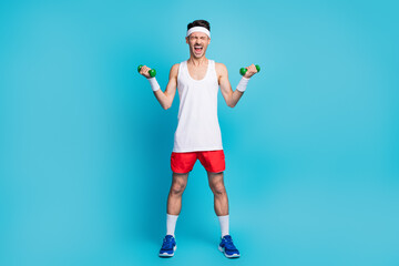 Full size photo of young sportsman do exercise scream heavy dumbells workout isolated over blue color background