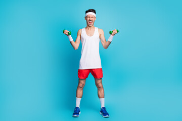 Full size photo of young sportsman do exercise scream heavy dumbells workout isolated over blue...