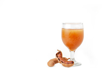 Homemade tamarind juice in a clear glass on a white background.