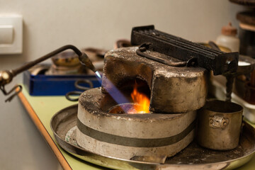 blowtorch melts silver in a jewelry workshop furnace
