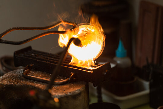 melting with blow torch and foundry of liquid silver from a bowl into a mold