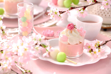 Fototapeta na wymiar Spring dessert plate with cherry blossom mousse and Three color dumplings. Beautiful cherry blossom background.　手作り桜スイーツ　おうちでお花見　ティータイム