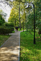 People walk in the city park in autumn.