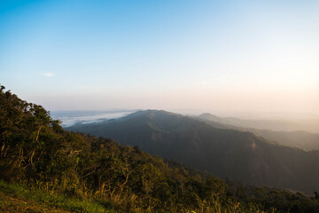 The green natural mountain view with fog in the morning
