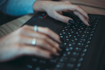 girl is typing text on the keyboard. close-up of hand keys