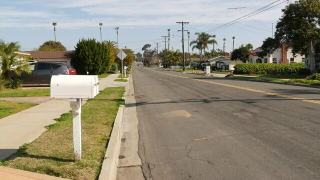 Houses on suburban street in California USA, Oceanside. Generic buildings in residential district near Los Angeles. Real estate property exterior. Tropical gardens, palms near typical american homes.